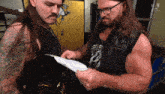 two men looking at a piece of paper with the letter n on the bottom