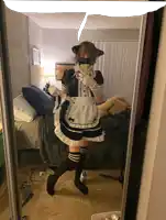 a person in a maid costume is taking a selfie in a mirror