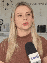 a woman talking into a microphone that says tem