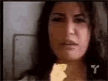 a woman is eating a piece of food in a video .