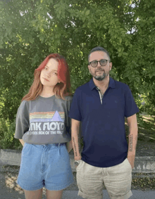 a man and a woman standing next to each other with one wearing a shirt that says pink floyd