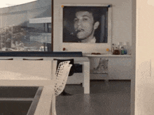 a picture of a man smoking a cigar is hanging on a wall in a living room .