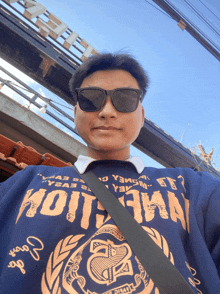 a man wearing sunglasses and a sweatshirt that says hotman