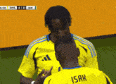 a man in a yellow shirt with the word isak on it