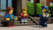 a group of lego figures standing on a sidewalk with one wearing a helmet with the letter m on it