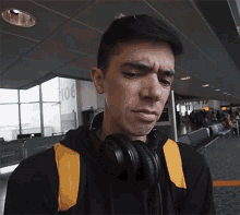 a man wearing headphones stands in front of a wall with the number 106 on it