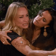 a woman with a ring on her finger is hugging another woman