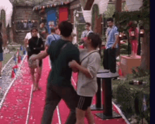 a man and a woman are dancing on a red carpet in front of a crowd of people .
