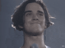 a close up of a man 's face with a microphone around his neck