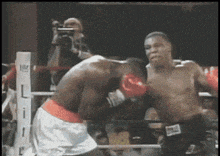 two men are boxing in a ring with the letter l visible