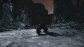 a silhouette of a person standing in the snow in a dark cave