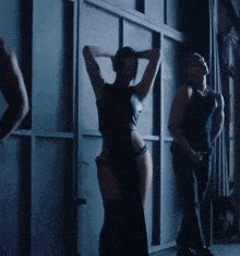a woman in a black bodysuit is dancing with a man