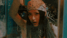 a woman wearing a bandana is holding another woman 's hand .