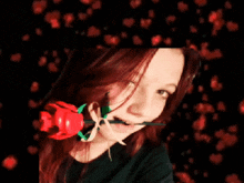 a girl holding a red rose in her mouth