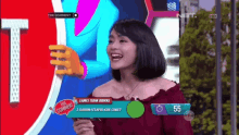 a woman is laughing in front of a tv screen that says the comment