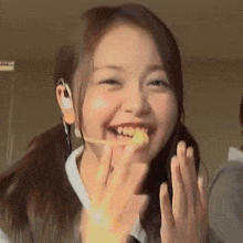 a young woman is eating a piece of food with her hands while wearing a headset .