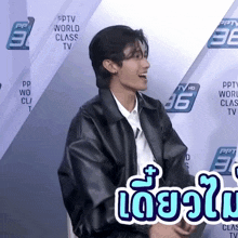 a man in a black jacket is laughing in front of a wall that says pptv world class tv on it