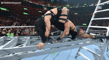 a female wrestler is laying on a metal ladder in a wrestling ring