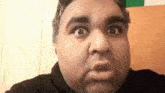 a close up of a man making a funny face while looking at the camera .