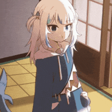 a girl in a blue hoodie is standing next to a shark in a room