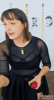 a woman in a black top with the word dipomite twins on the bottom left