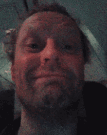 a man with a beard is making a funny face in a bathroom .