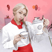 a woman is holding a teapot and a cup of tea in her hands