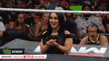 a woman sitting in a wrestling ring with peacock in the u.s. and netflix internationally at the bottom
