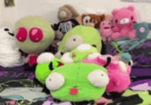 a bunch of stuffed animals are laying on top of each other on a bed .