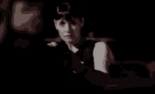 a woman in a fbi vest is standing in the dark looking at a man .