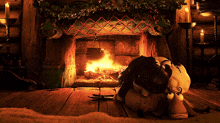 a person laying in front of a fireplace with candles on the mantle