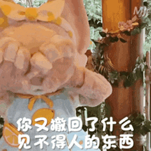 a stuffed animal with chinese writing on it covering her eyes