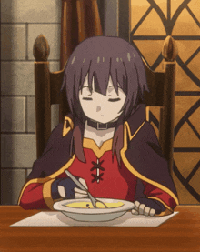 a girl is sitting at a table with a bowl of soup in front of her