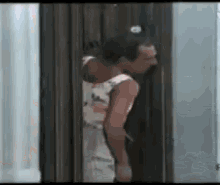 a man is standing in a doorway with his head in his hand .