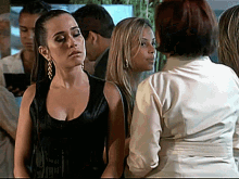 a woman in a black tank top is standing in a crowd