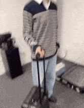 a man in a striped sweater is pulling a black suitcase