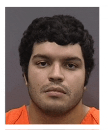 a man with curly hair and a beard wearing an orange shirt