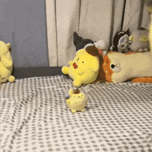a bunch of stuffed animals are laying on a bed including pompompurin