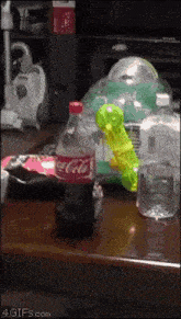 a bottle of coca cola is sitting on a table next to a water bottle