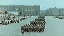 a group of soldiers marching down a street in front of a large building