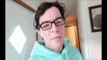 a man wearing glasses and a blue hoodie
