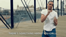 a man is dancing on a bridge with the words " there 's something about you girl "