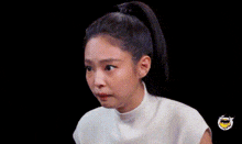a close up of a woman wearing a white shirt and a ponytail .