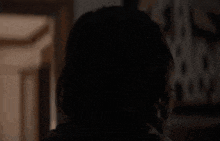 a close up of a woman 's face in a dark room smiling