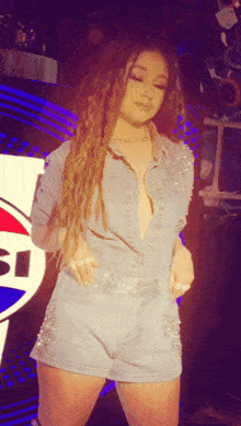 a woman standing in front of a pepsi logo