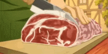 a person is cutting a large piece of meat on a cutting board with a knife .