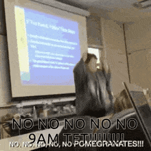 a man is giving a presentation in front of a projector screen that says no no no no 9 am tet