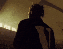 a man with dreadlocks is wearing a black jacket with the letter v on it .