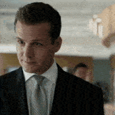 a man in a suit and tie is looking at something