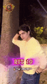 a young man standing in front of a tree with rit 10 on the bottom right